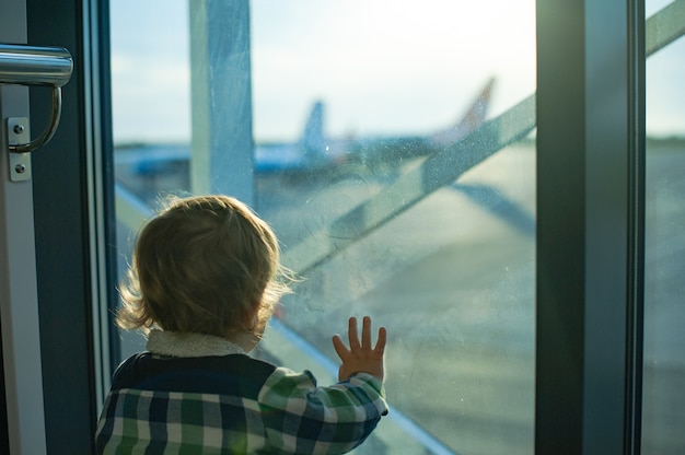 Chico mira por la ventana en el aeropuerto