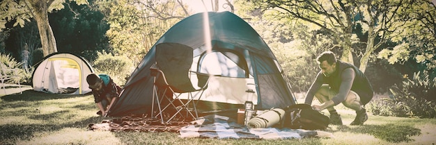 Chico montando la carpa en el camping.