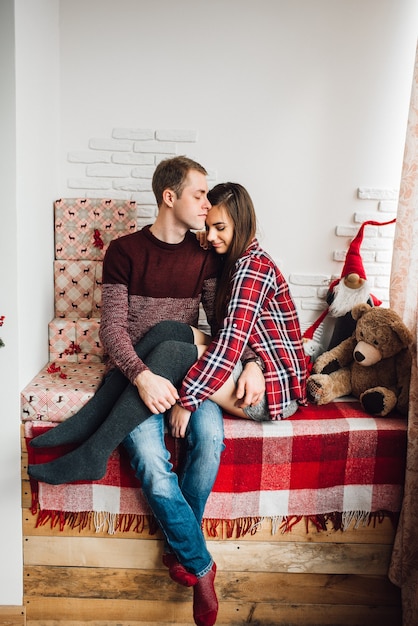 Un chico y una mujer celebran la Navidad juntos en un ambiente cálido.