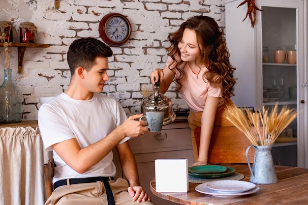 Un chico y una mujer están desayunando en la cocina con un plato blanco en blanco sobre la mesa