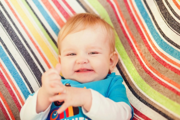 Chico muy divertido tumbado en el sofá y sonriendo.