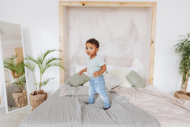 Chico negro en la cama. Retrato de un niño afroamericano.