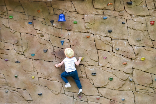 Foto el chico está ocupado en la escalada en roca