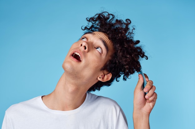 Chico con peine de pelo rizado en el estilo de vida de las emociones del cabello de cerca