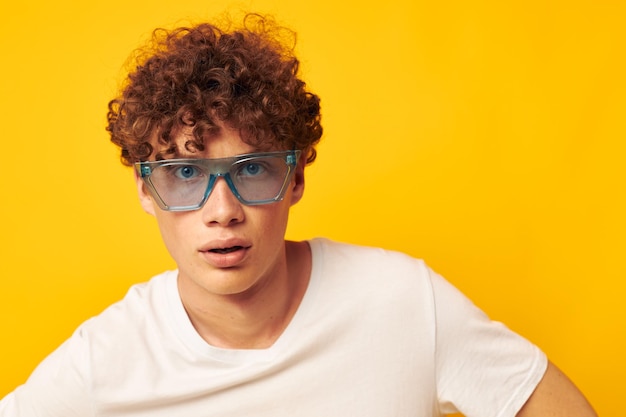 Chico con pelo rizado rojo en una camiseta blanca gafas de moda azul estilo de vida inalterado