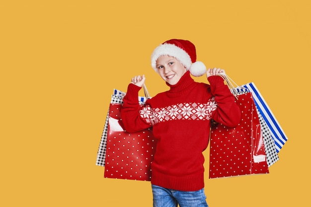 Chico positivo con sombrero de Santa con regalos