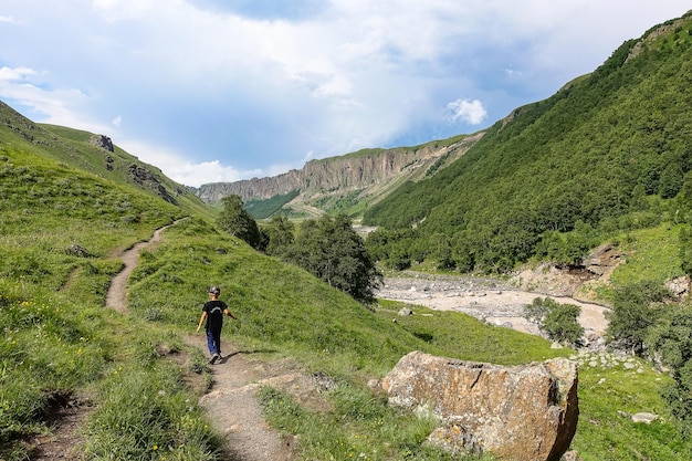 Chico en el río KyzylKol rodeado por las montañas del Cáucaso cerca de Elbrus Jilysu Rusia