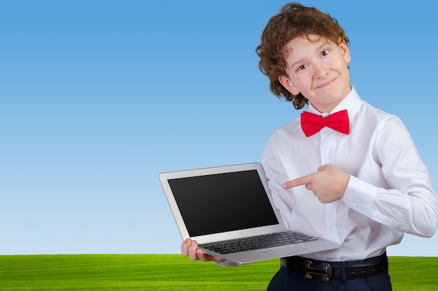 Chico rizado en traje formal con laptop