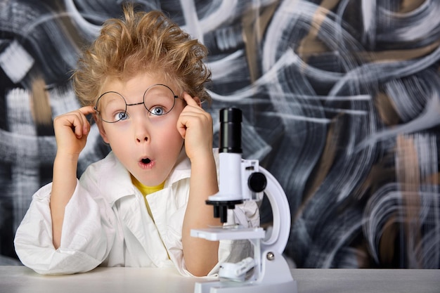 El chico rubio se abultó los ojos con sorpresa realizando experimentos en el laboratorio.