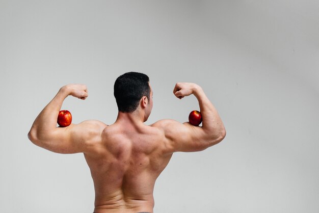 Foto chico sexy deportivo posando con frutas brillantes. dieta. dieta saludable