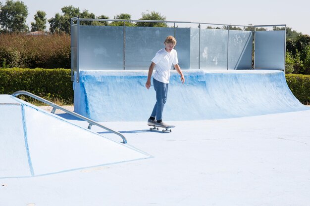 Chico skater se prepara para un truco en un parque de patinetas y paseos