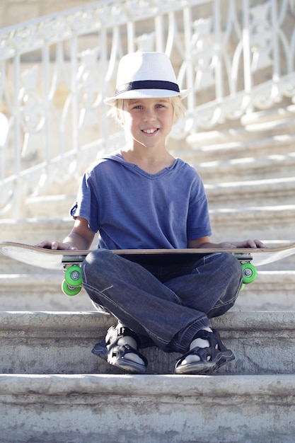 Chico skater sentado con un longboard