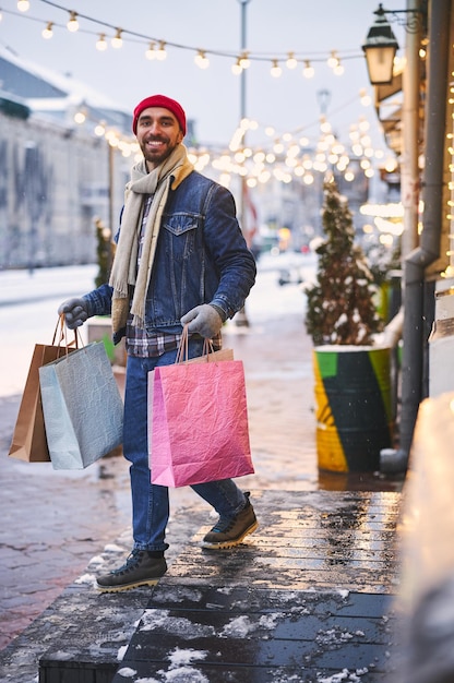 Chico sonriente disfrutando de las compras en la ciudad nevada