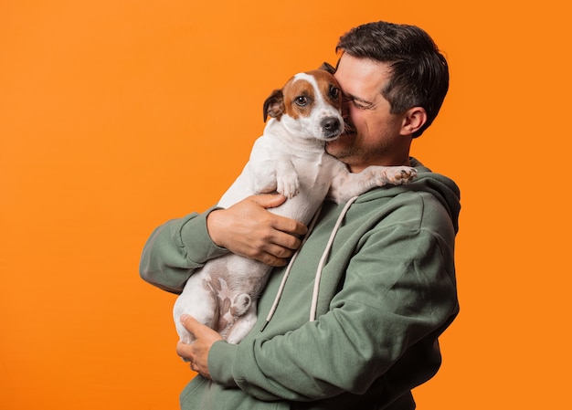 Chico sonriente feliz con un perro en naranja