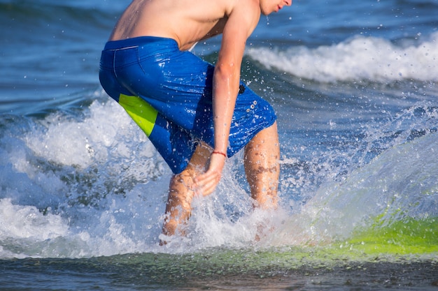 Chico surfista surfeando olas en la playa