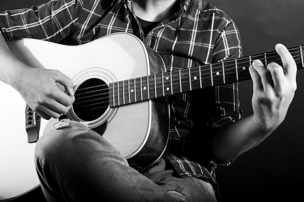 Chico tocando una guitarra acústica en un estudio de grabación