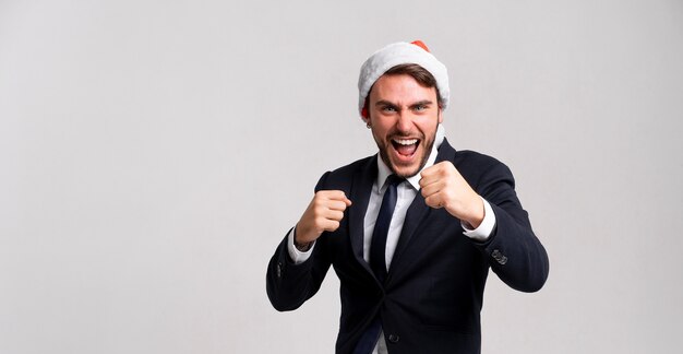 chico en traje de negocios y gorro de Papá Noel