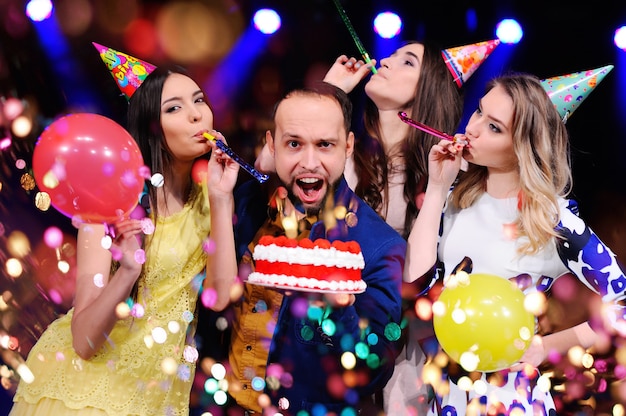 Un chico y tres chicas se regocijan y celebran la fiesta en el club nocturno.