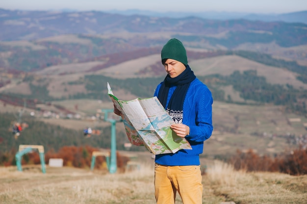 chico turista en las montañas con mapa