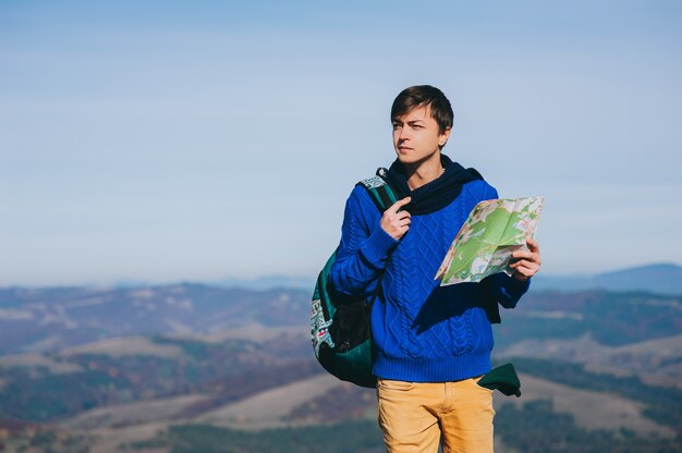 chico turista en las montañas con mapa