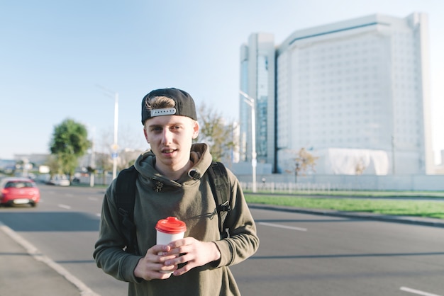 Chico urbano guapo con una taza de papel