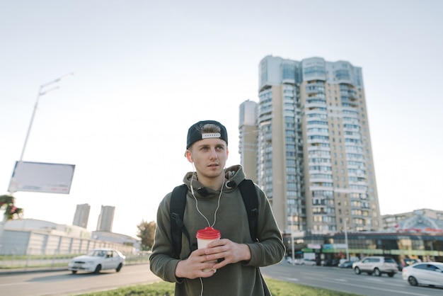 Chico urbano guapo con una taza de papel