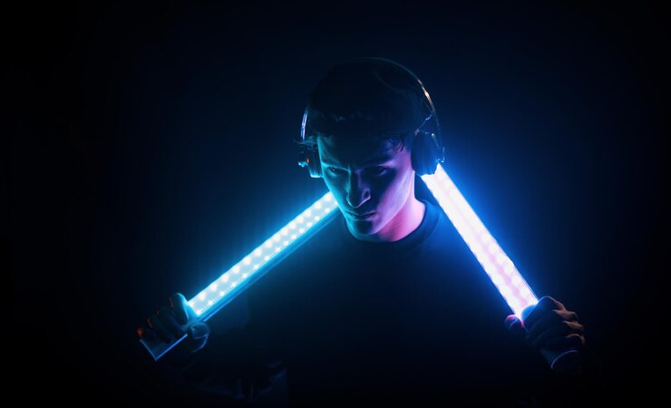 Foto chico usa auriculares iluminación de neón joven europeo está en el estudio oscuro