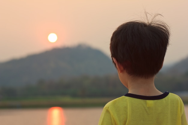 Foto el chico ve el atardecer.