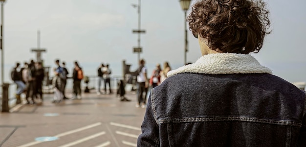 Chico con vistas a la gente en el muelle