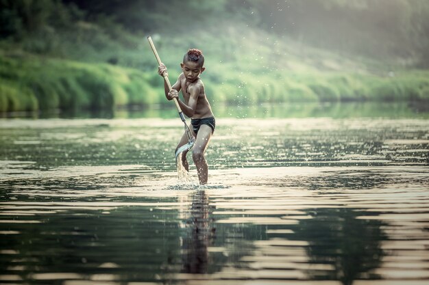 Chicos asiáticos pescando en el río