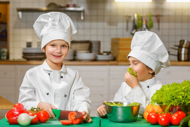 Chicos divertidos feliz chef cocinando en la cocina del restaurante