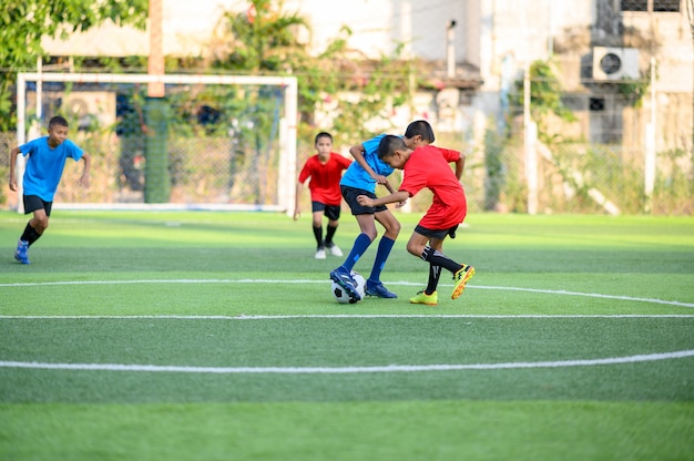 Foto chicos jugando al fútbol en el campo de práctica de fútbol