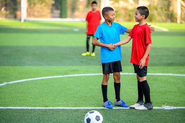 Chicos jugando al fútbol en el campo de práctica de fútbol