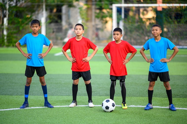 Chicos jugando al fútbol en el campo de práctica de fútbol