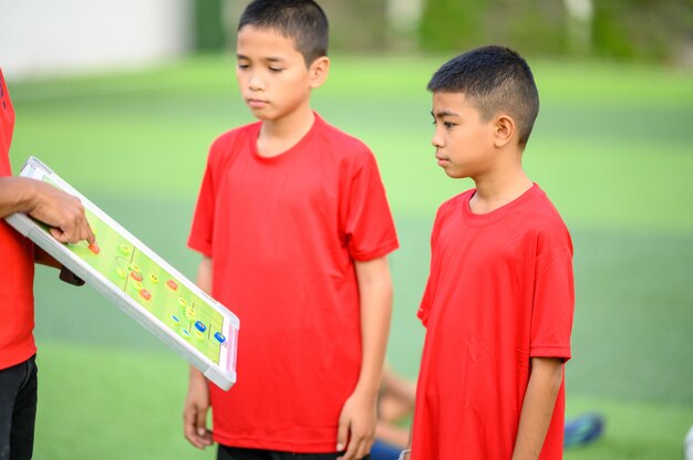 Chicos jugando al fútbol en el campo de práctica de fútbol