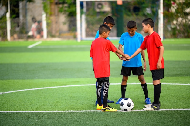 Chicos jugando al fútbol en el campo de práctica de fútbol