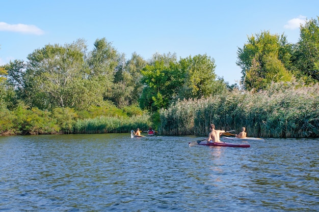 Chicos reman canoas en el río