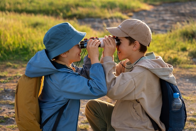 Foto chicos de tiro medio explorando la naturaleza.