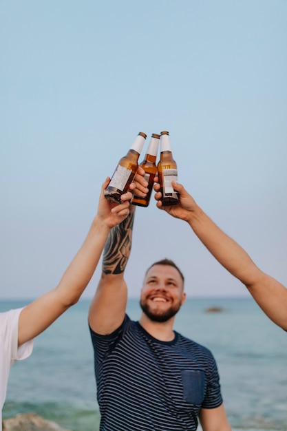 Foto chicos tomando cervezas en la playa.