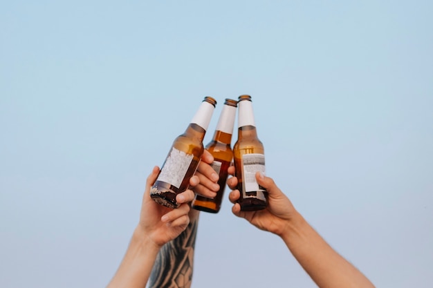 Foto chicos tomando cervezas en la playa.