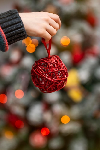 Child39s Hand, die eine Weihnachtsbaumverzierung hält