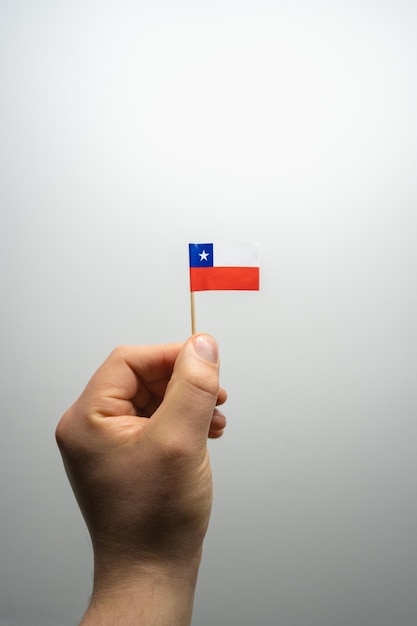 Foto chile-flagge in einer hand mit weißem hintergrund