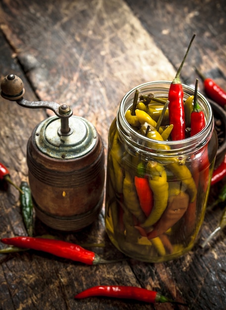 Chiles en escabeche con especias. Sobre un fondo de madera.