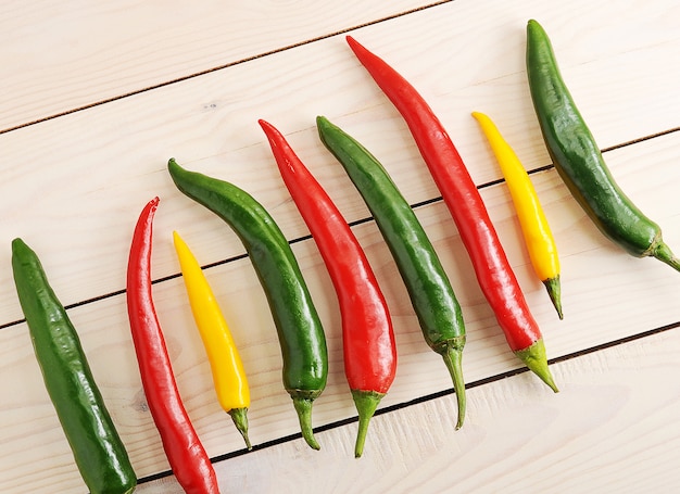 Los chiles están en una fila con ají amarillo, verde y rojo.