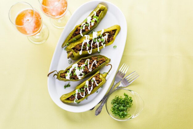 Chiles rellenos de ternera con chipotle y frijoles aderezados con crema agria y cebolletas.