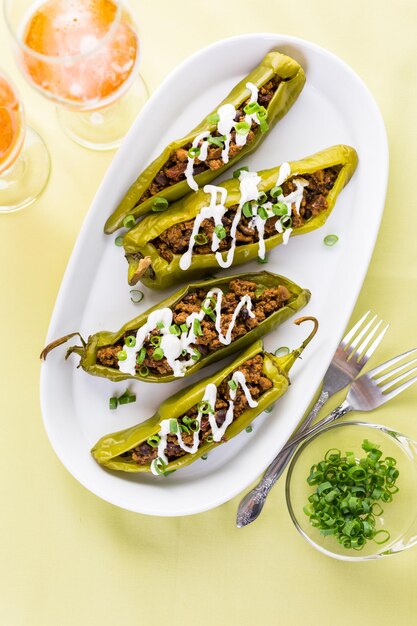 Chiles rellenos de ternera con chipotle y frijoles aderezados con crema agria y cebolletas.