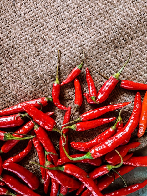 Chiles rojos frescos sobre fondo de tela vintage.