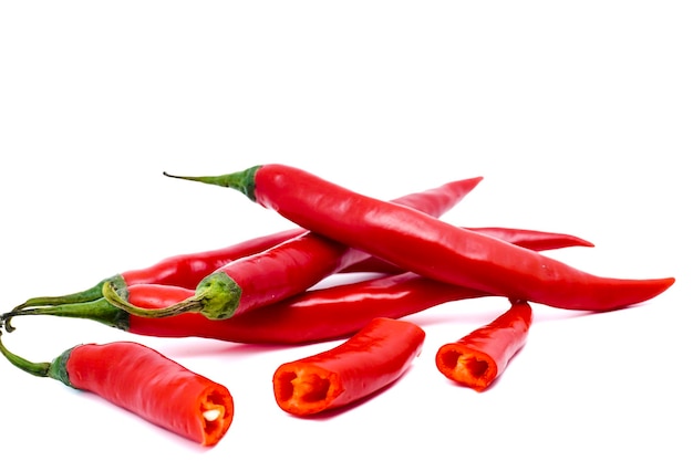 Chiles rojos con rodajas aisladas sobre fondo blanco con espacio de copia Chiles maduros Concepto de ingrediente de alimentos crudos