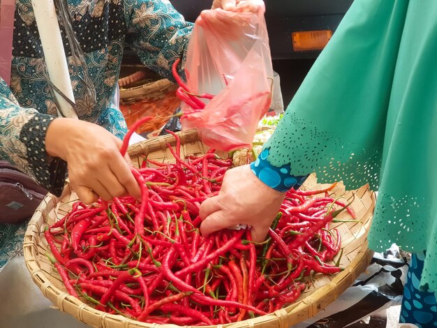 chiles rojos entre vendedores y compradores en el mercado de verduras