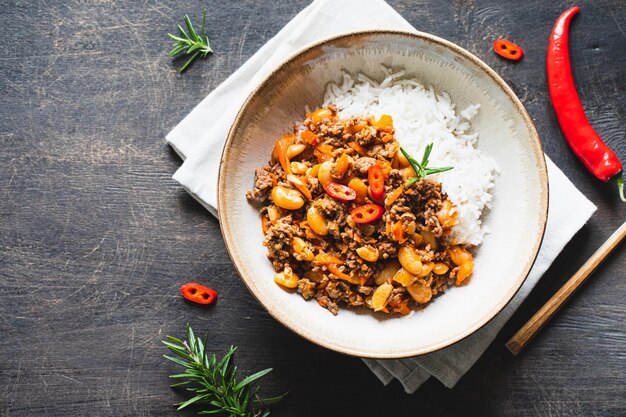 Chili Con Carne en un tazón sobre fondo oscuro Cocina mexicana chili con carne estofado de carne picada y verduras en salsa de tomate Vista superior